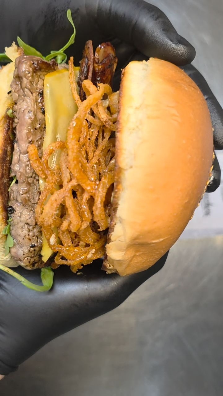 Hamburguesa de Caracuchos sostenida durante su preparación